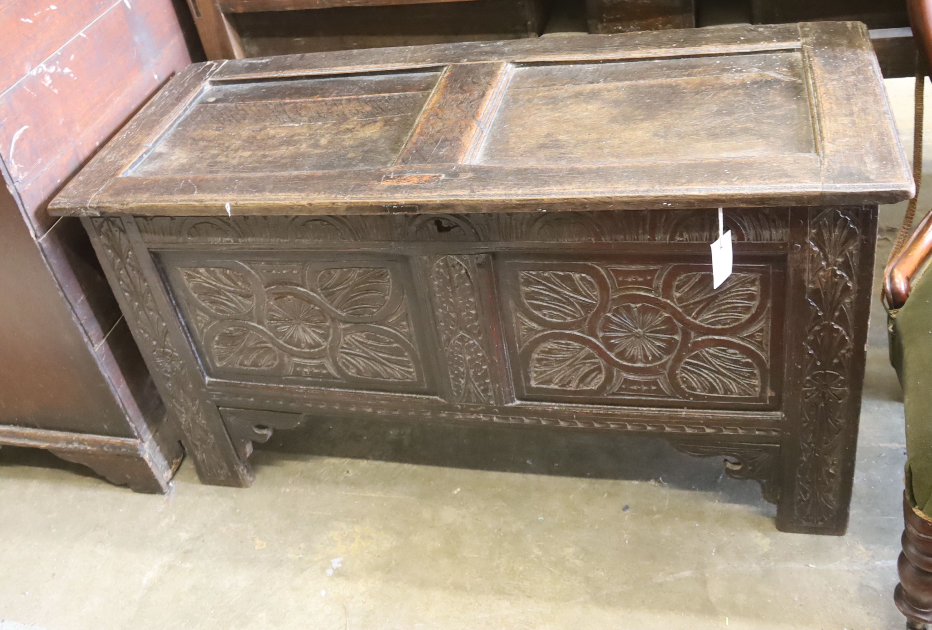 An 18th century oak coffer, later carved, length 116cm, depth 46cm, height 62cm
